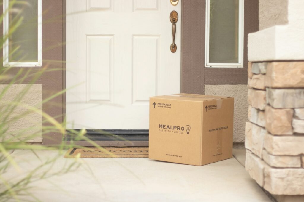 A brown cardboard box beside a white wooden door